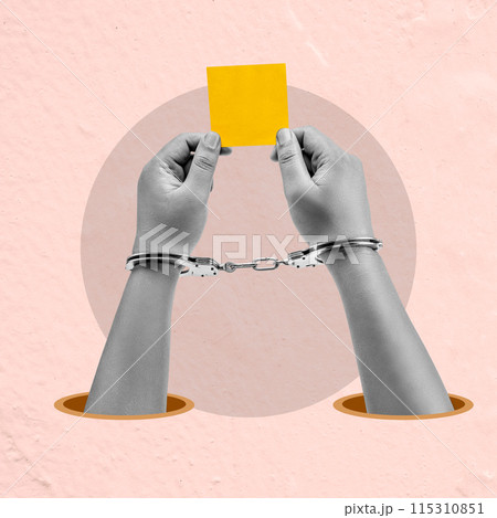 A man is holding a yellow piece of paper with handcuffs on it 115310851