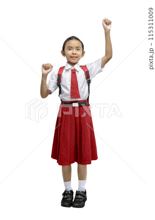 Portrait of an Asian elementary school student girl in uniform with a backpack raised hand in the air Portrait of an Asian elementary school student girl in uniform with a backpack raised hand in the air 115311009