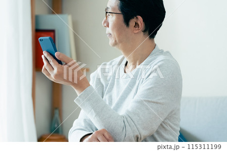 スマホをチェックするミドル男性 115311199