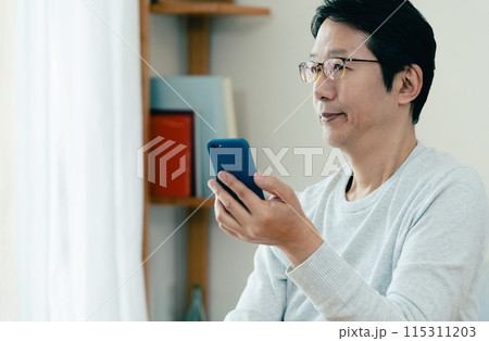 スマホをチェックするミドル男性 115311203