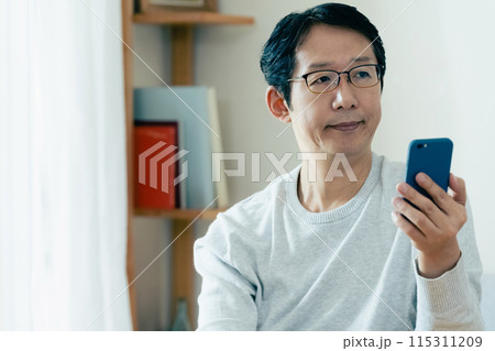 スマホをチェックするミドル男性 115311209