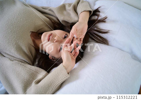 布団の上でくつろぐ女性 布団の上でくつろぐ女性 115312221