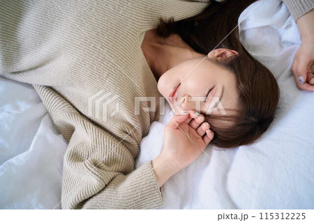 布団の上でくつろぐ女性 115312225