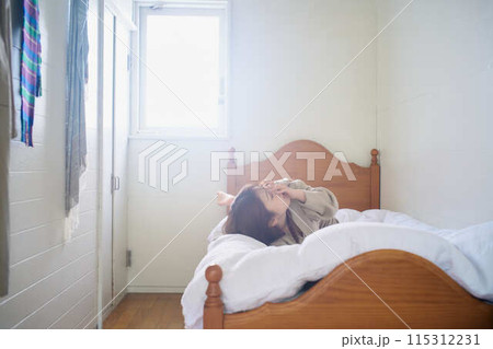 布団の上でくつろぐ女性 布団の上でくつろぐ女性 115312231