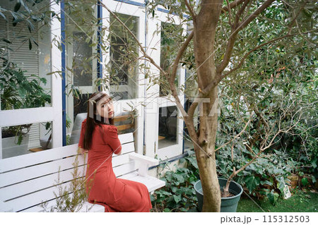 庭でくつろぐ若い女性のポートレート 115312503