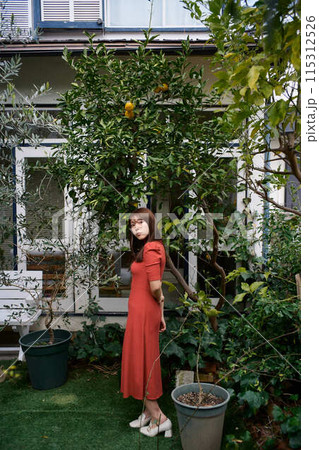 庭でくつろぐ若い女性のポートレート 庭でくつろぐ若い女性のポートレート 115312526