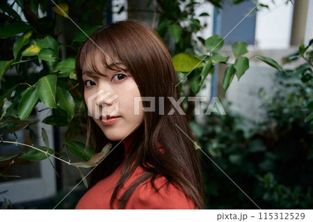 庭でくつろぐ若い女性のポートレート 庭でくつろぐ若い女性のポートレート 115312529