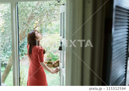 扉を開ける若い女性 扉を開ける若い女性 115312594