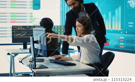 Enterprise colleagues reviewing project updates and details in monitoring room, establishing budget and other resources to achieve strategic business goals. Multiple corporation operations. camera A. 115313224