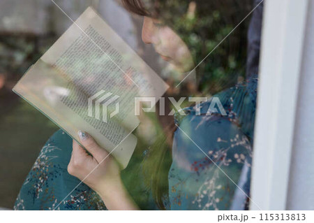 窓辺で本を読む女性 115313813
