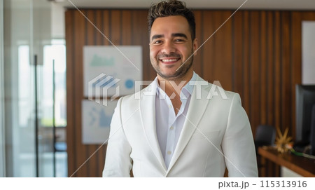 Professional Young Businessman in Modern Office Setting Wearing White Blazer - Corporate, Leadership, Confidence, and Success Concept 115313916