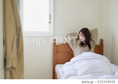 ベッドで寛ぐ女性 115314010