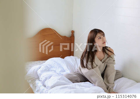 ベッドで寛ぐ女性 115314076