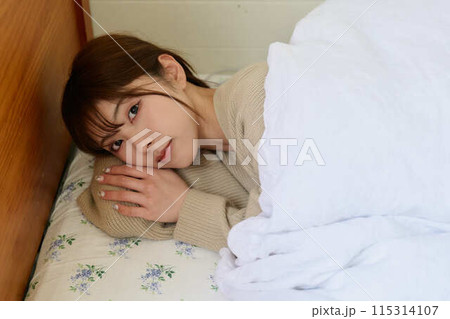 ベッドで寝ている女性 ベッドで寝ている女性 115314107