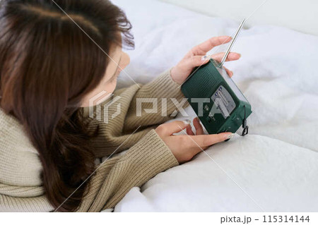 ベッドでラジオを見る女性 115314144