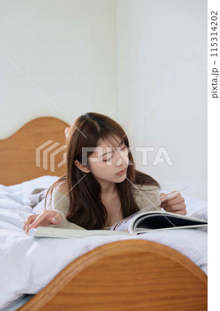 ベッドで読書する女性 115314202