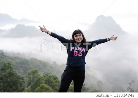 Asian woman freedom journey with valley mountain and foggy in natural and travel destination in tropical rain forest 115314748