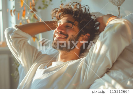 A Man Smiling While Relaxing in Bed During the Day 115315664