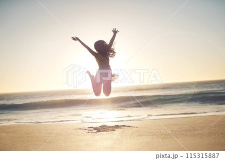 Woman, winner and jump with silhouette at beach with sunset sky, mock up space and celebration. Girl, person and hands up with cheers, stretching and summer sunshine at dusk with success by ocean 115315887