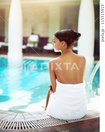 Woman, spa and relax by pool for holiday, calm and rest for vacation at resort for salon treatment. Towel, gown and female person for peace and swim, Thailand and luxury for wellness on break or nap Woman, spa and relax by pool for holiday, calm and rest for vacation at resort for salon treatment. Towel, gown and female person for peace and swim, Thailand and luxury for wellness on break or nap 115315919
