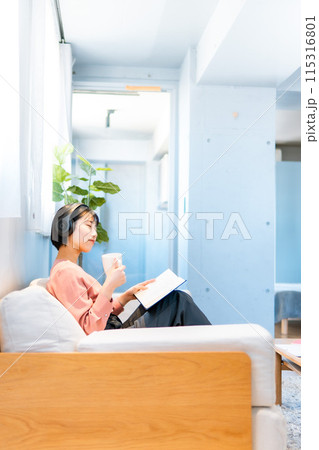 音楽を聴きながら読書をする女性/リスキリング 115316801