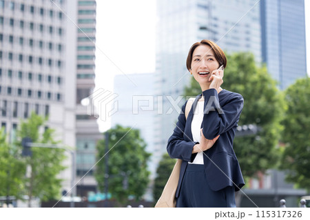 ビジネス スマホ 通話をしているミドル女性 ビジネス スマホ 通話をしているミドル女性 115317326