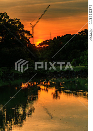 奈良公園鷺池　浮見堂の夕景　西の空を黄金色に染めながら興福寺へ沈んで行く夕日⑮ 115318375