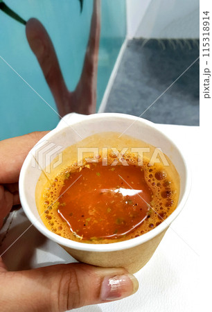 woman's hand holding tomato soup in a cup woman's hand holding tomato soup in a cup 115318914