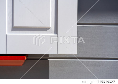 White shutters on a gray facade with red. High quality photo. Abstract minimalistic background 115319327