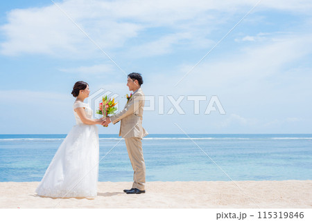 南国の海でブーケを持つ新郎新婦 南国の海でブーケを持つ新郎新婦 115319846