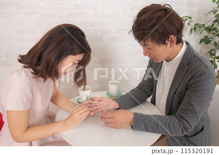 デート中、喫茶店で手相を見るカップル 115320191