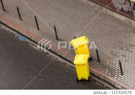 Plastic wheely bins in the street outside Plastic wheely bins in the street outside 115320579