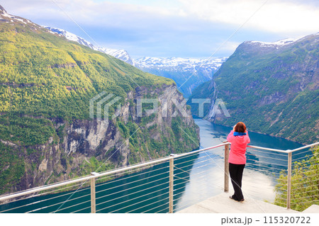 Tourist looking at Geirangerfjord from Flydasjuvet viewpoint Norway 115320722