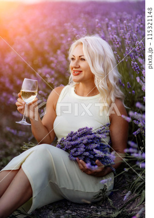 Blonde lavender field holds a glass of white wine in her hands. Happy woman in white dress enjoys lavender field picnic holding a large bouquet of lavender in her hands . Illustrating woman's picnic Blonde lavender field holds a glass of white wine in her hands. Happy woman in white dress enjoys lavender field picnic holding a large bouquet of lavender in her hands . Illustrating woman's picnic 115321148