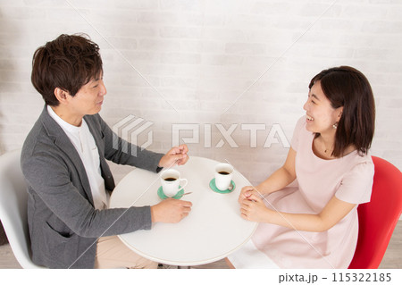 喫茶店で語り合う若いカップル 115322185