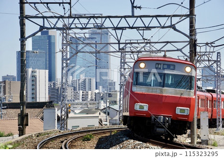 名古屋のビルを背景に走る名鉄電車 115323295