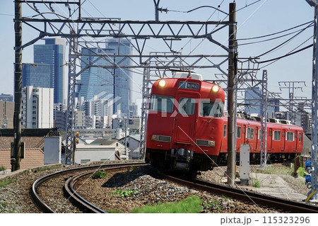 名古屋のビルを背景に走る名鉄電車 115323296