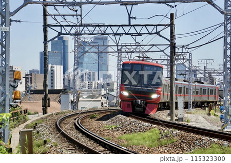 名古屋のビルを背景に走る名鉄電車 115323300