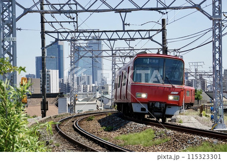 名古屋のビルを背景に走る名鉄電車 115323301