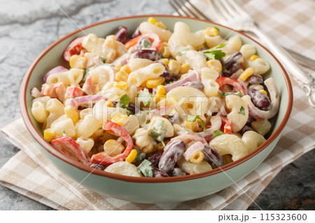 Delicious American macaroni pasta salad with onions, corn, beans, peppers with ranch dressing close-up in a bowl. Horizontal Delicious American macaroni pasta salad with onions, corn, beans, peppers with ranch dressing close-up in a bowl. Horizontal 115323600
