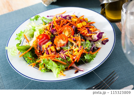 Appetizing salad of various vegetables - lettuce, tomatoes, corn, onions 115323809
