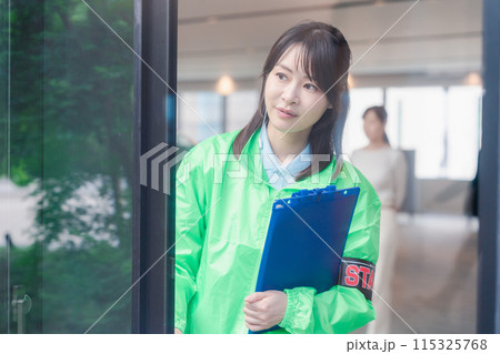 笑顔で案内をするイベントスタッフ 115325768