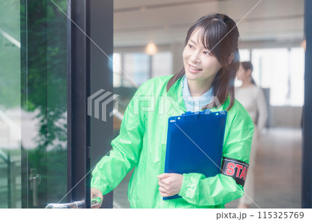 笑顔で案内をするイベントスタッフ 115325769