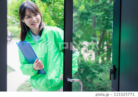 笑顔で案内をするイベントスタッフ 115325771