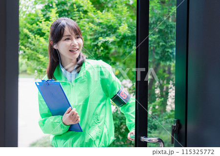 笑顔で案内をするイベントスタッフ 115325772