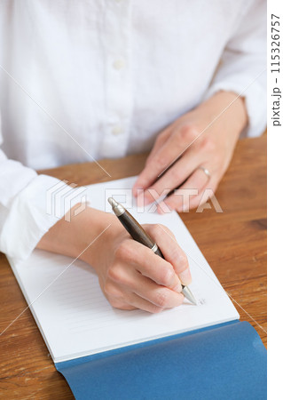 リビングで家族へ手紙を書くミドル女性 リビングで家族へ手紙を書くミドル女性 115326757