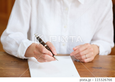 リビングで家族へ手紙を書くミドル女性 リビングで家族へ手紙を書くミドル女性 115326766
