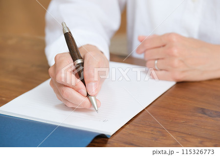 リビングで家族へ手紙を書くミドル女性 リビングで家族へ手紙を書くミドル女性 115326773