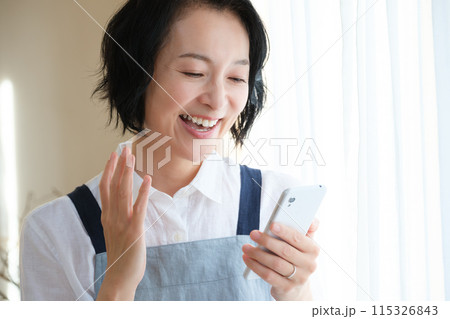 リビングでスマホを操作するミドル女性 リビングでスマホを操作するミドル女性 115326843