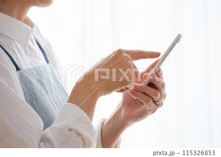 リビングでスマホを操作するミドル女性 リビングでスマホを操作するミドル女性 115326853
